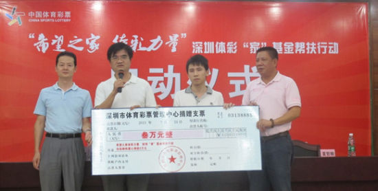 深圳市文體旅游局巡視員柯剛明(左二)和深圳市體彩中心主任夏哲順(右一)代表深圳體彩人對(duì)張炳偉捐助3萬元